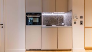 A modern kitchen with built-in appliances, a sink, and a countertop. - Opera - One Bedroom Balcony (Paris)