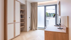 A modern room with a wardrobe, a desk, and a large window with curtains. - Opera - One Bedroom Balcony (Paris)