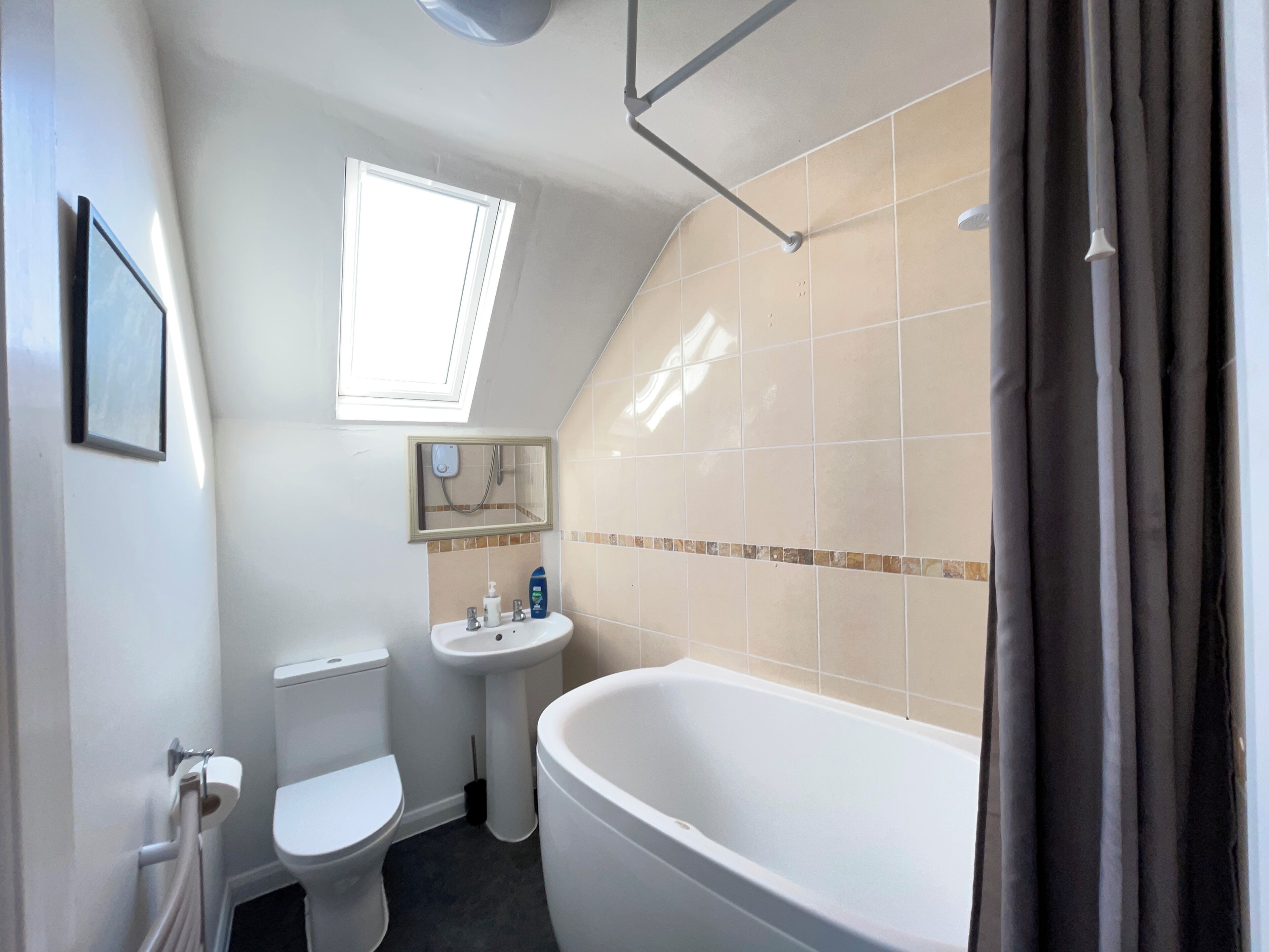 A bathroom with a toilet, sink, and bathtub.