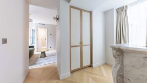 A room with a wooden floor, a marble column, and a door with glass panels.