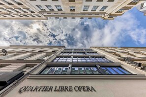 Een gebouw met het bord 'QUARTIER LIBRE OPERA', wat een hotel of een operahuis aanduidt.