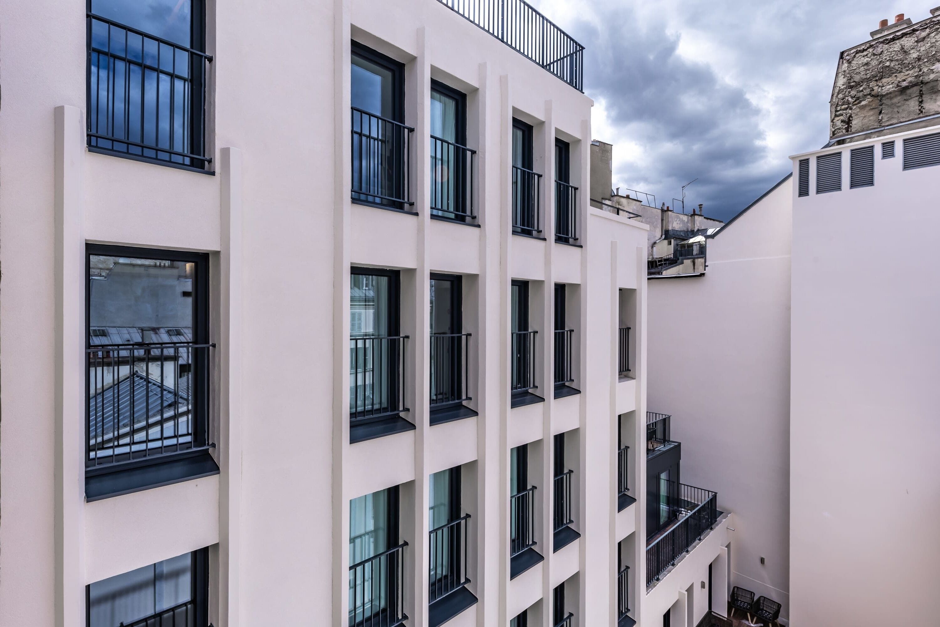 Un edificio de varios pisos con balcones y ventanas grandes.