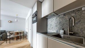 Una cocina moderna con encimera de granito, pileta de acero inoxidable y horno integrado.