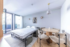 Un dormitorio moderno con cama, una mesa de comedor y sillas.