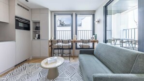 A modern apartment with a kitchen, dining area, and a balcony with a view.