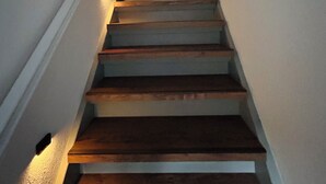 Un escalier avec des marches en bois et des murs blancs.