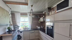 A compact kitchen with a washing machine, a built-in oven, and a sink. - Bad Füssing ... time out for two ...  (Bad Füssing)