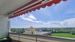 A balcony with a view of a green field and buildings in the distance. - Bad Füssing ... time out for two ...  (Bad Füssing)