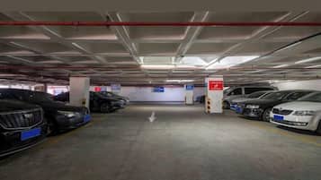 A multi-level parking garage with cars parked in designated spaces, clear directional signage, and a visible exit.