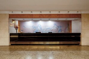 A reception area with a marble floor, a reception desk, and a wall-mounted artwork. - Changzhou Soluxe International Grand Hotel (Qingguo Lane Wuyue Plaza) (Changzhou)