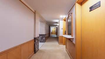 A hotel corridor with wooden paneling, a marble wall, and a sign indicating room number 2606.