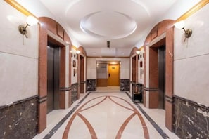A hotel corridor with marble flooring, wall sconces, and a circular ceiling design. - Changzhou Soluxe International Grand Hotel (Qingguo Lane Wuyue Plaza) (Changzhou)