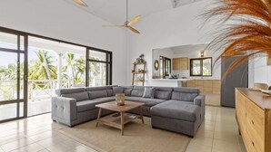 A spacious living area with a large gray sectional sofa, a wooden coffee table, and a ceiling fan. - Villa 3 Anses - Three Bedroom Villa, Sleeps 8 (Sainte-Anne)