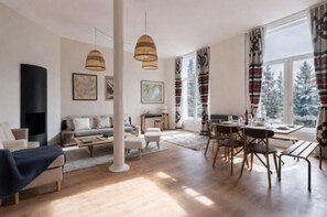 Una sala de estar moderna con sofá, mesa de centro y comedor.