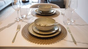 A dining table set with a bowl, spoon, fork, and knife.
