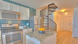 A kitchen with a microwave, stove, refrigerator, and a bowl of oranges on the counter. - NEW! Beachside Bliss in Orange Beach (Orange Beach)