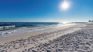 A wide sandy beach with footprints, waves, and a clear blue sky. - NEW! Beachside Bliss in Orange Beach (Orange Beach)