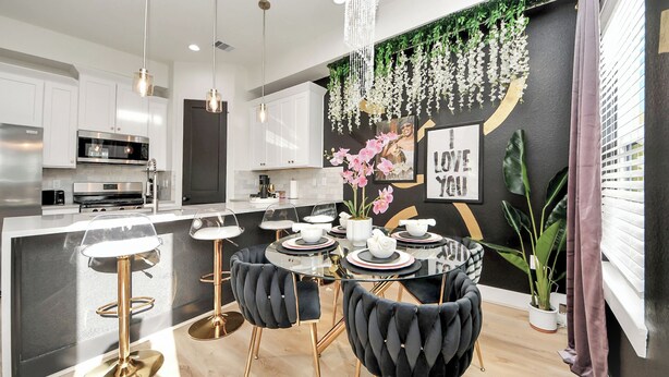 A modern kitchen with white cabinets, stainless steel appliances, and a glass dining table with black upholstered chairs. - Toast & Groove - Sleeps 16 - HTX (Houston)