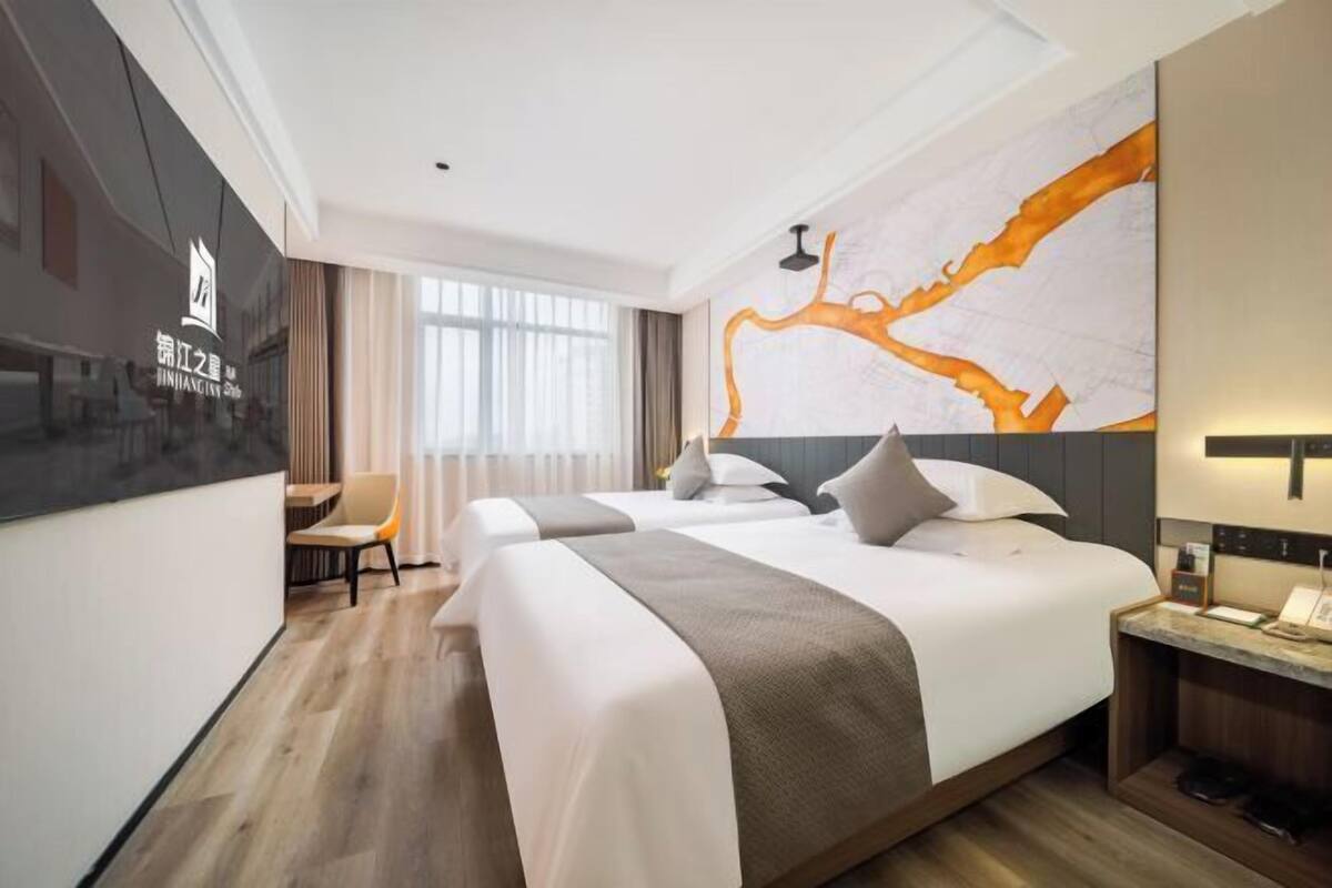A hotel room with a large bed, a desk, and a view of a river through the window.