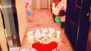 Un corridoio con un cartello che recita 'HAPPY' e decorazioni a forma di cuore sul pavimento.