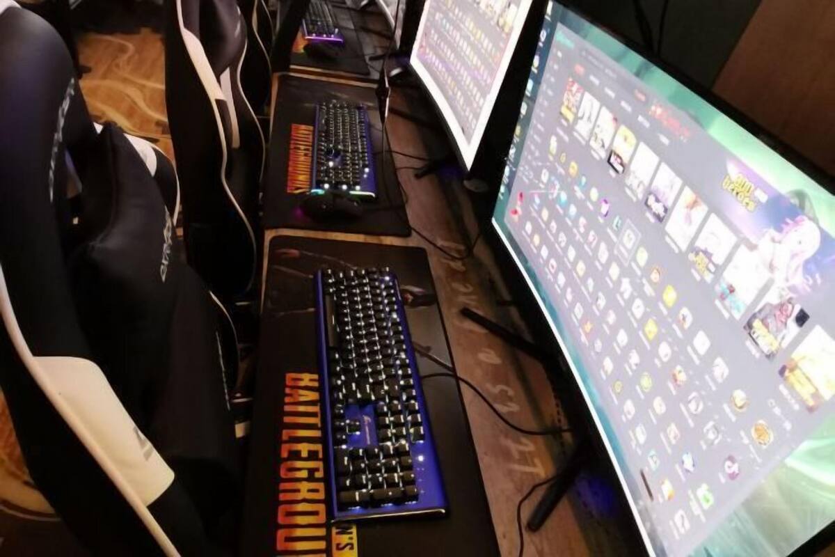 A gaming setup with multiple keyboards, a monitor displaying a game interface, and a chair.