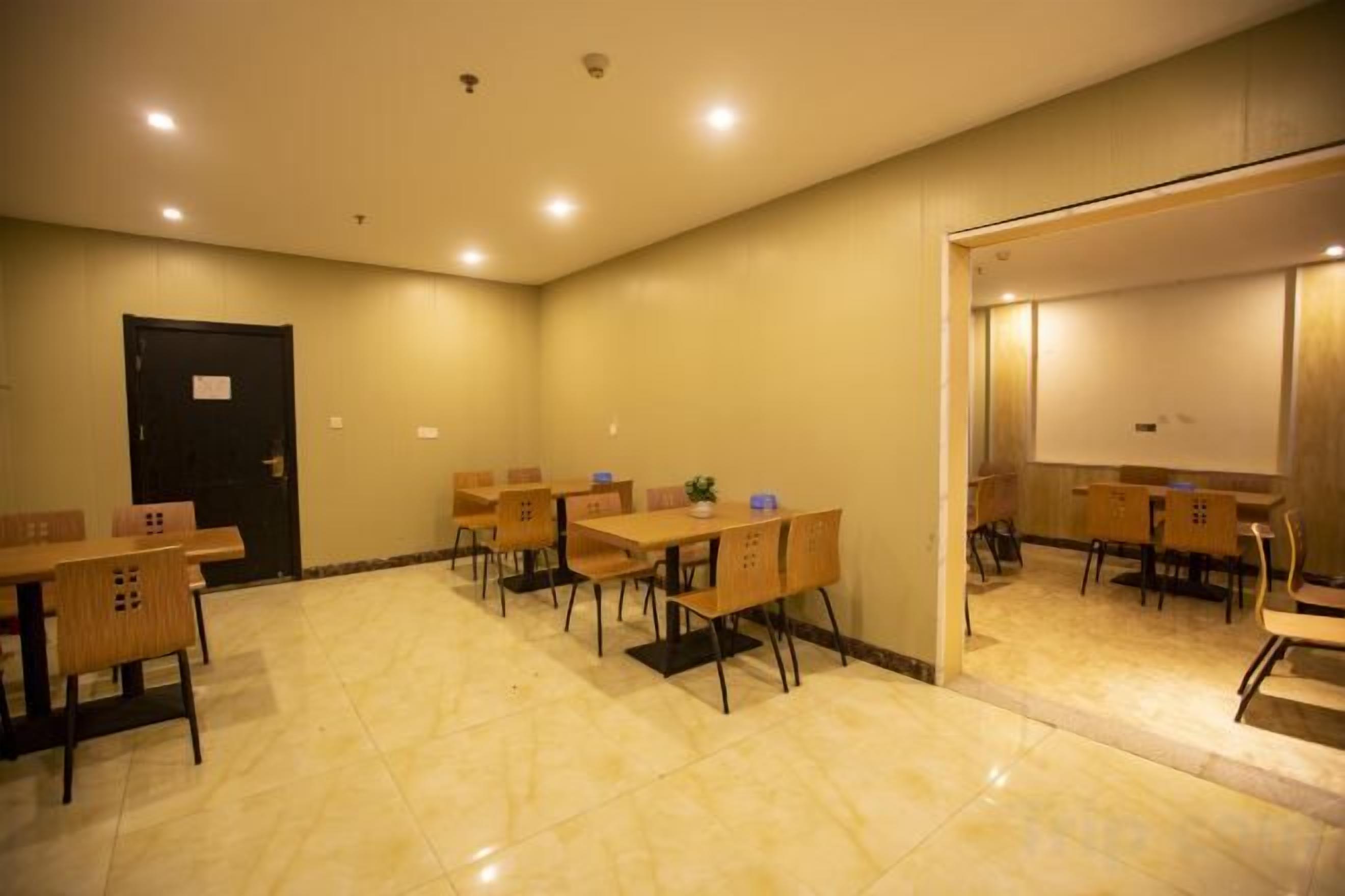 A conference room with tables and chairs, a door, and a projection screen.