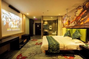 A hotel room with a bed, a TV screen, a desk, and a bathroom visible through a glass door. - Tehaote Hotel of Zheng Zhou (Zhengzhou)