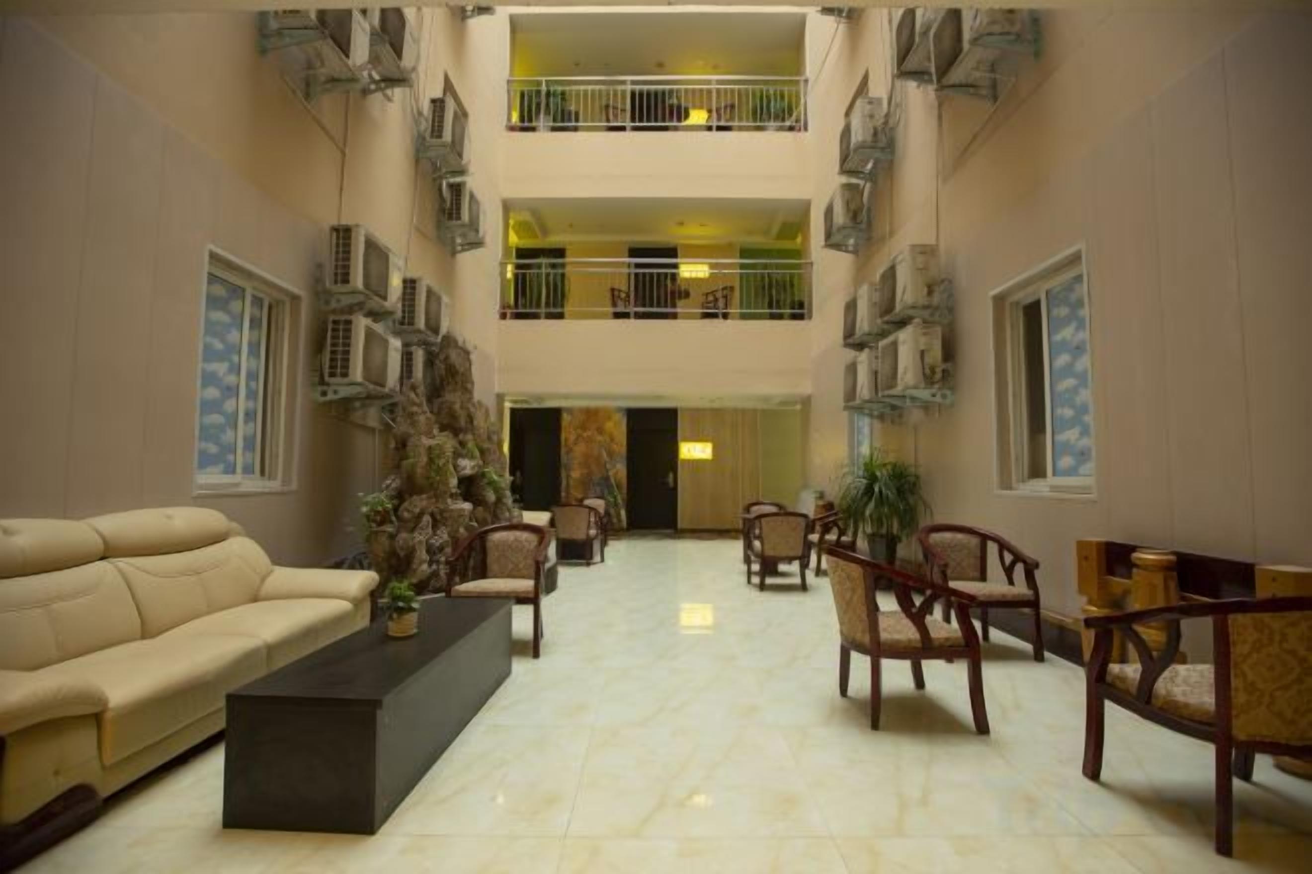 A spacious lobby with a high ceiling, multiple seating areas, and a central decorative piece.