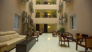 A spacious lobby with a high ceiling, multiple seating areas, and a central decorative piece.