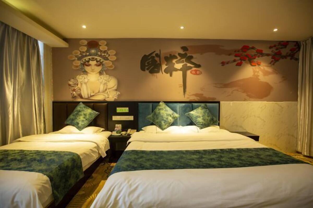 A hotel room with two beds, a mural, and a nightstand.