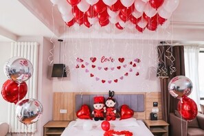 A hotel room with a bed, a bedside table, a TV, and a wall-mounted shelf. - Tehaote Hotel of Zheng Zhou (Zhengzhou)