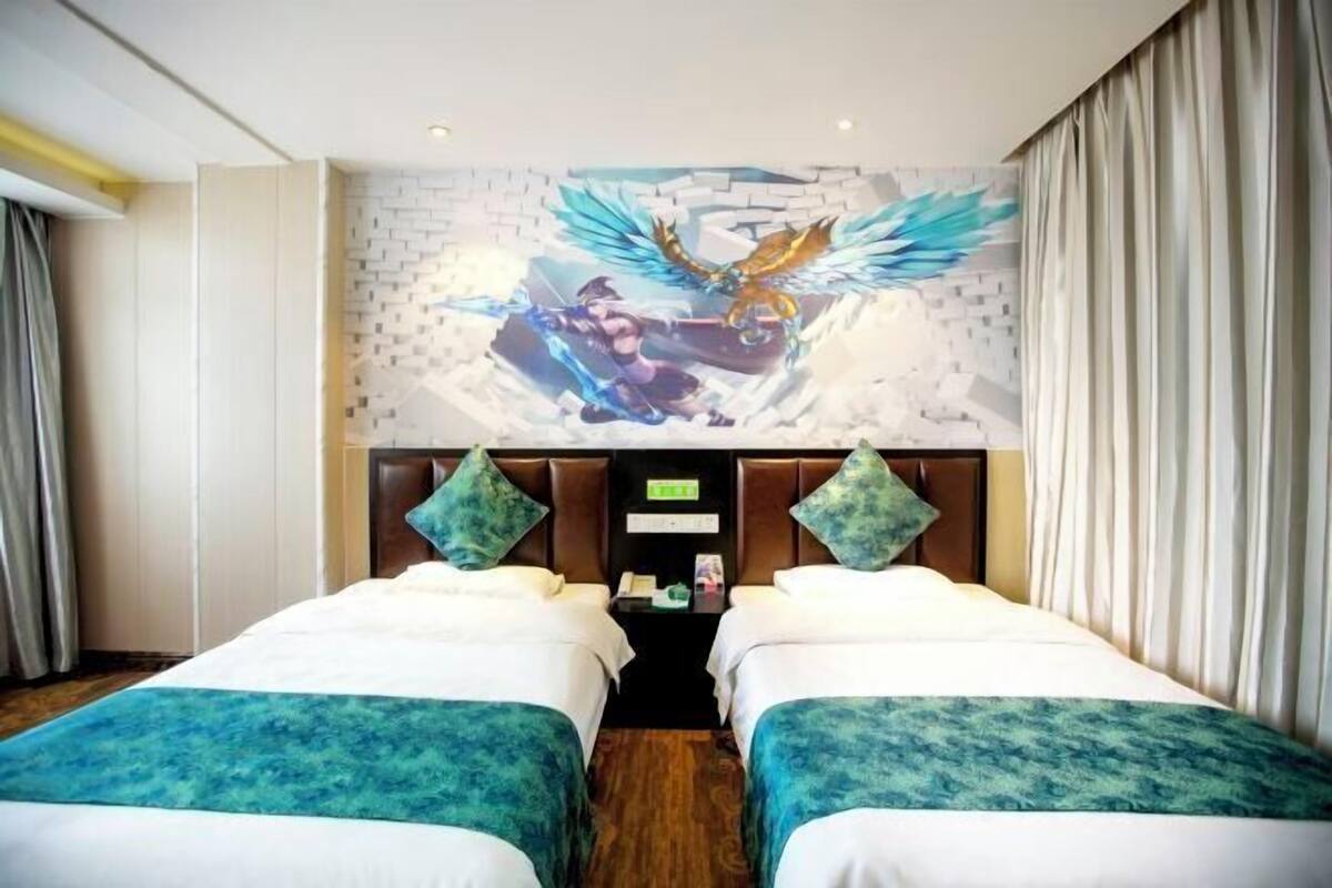 A hotel room with two beds, a mural on the wall, a nightstand, and curtains.