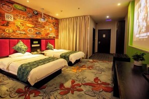 A hotel room with two beds, a red headboard, a floral carpet, and a wall decorated with various car logos.