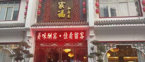 A traditional Chinese building with a red entrance and golden signage.