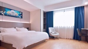 A modern hotel room with a large bed, a desk, and a chair. - Jin Jiang Hotel (Cangnan)