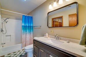 Un baño con bañera, ducha, inodoro y lavamanos.