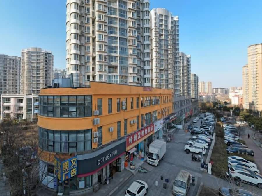 A multi-story building with a parking lot in front.