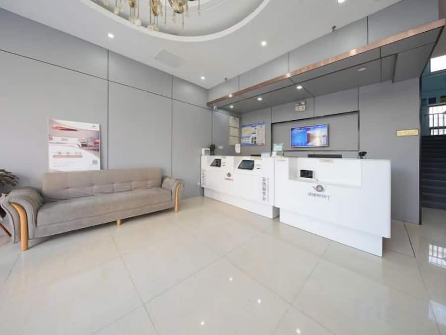 A reception area with a sofa, a reception desk, and a staircase.