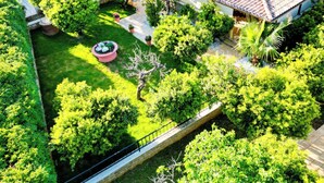 A residential area with a well-maintained garden, a solar panel installation on the roof, and a stone pathway.