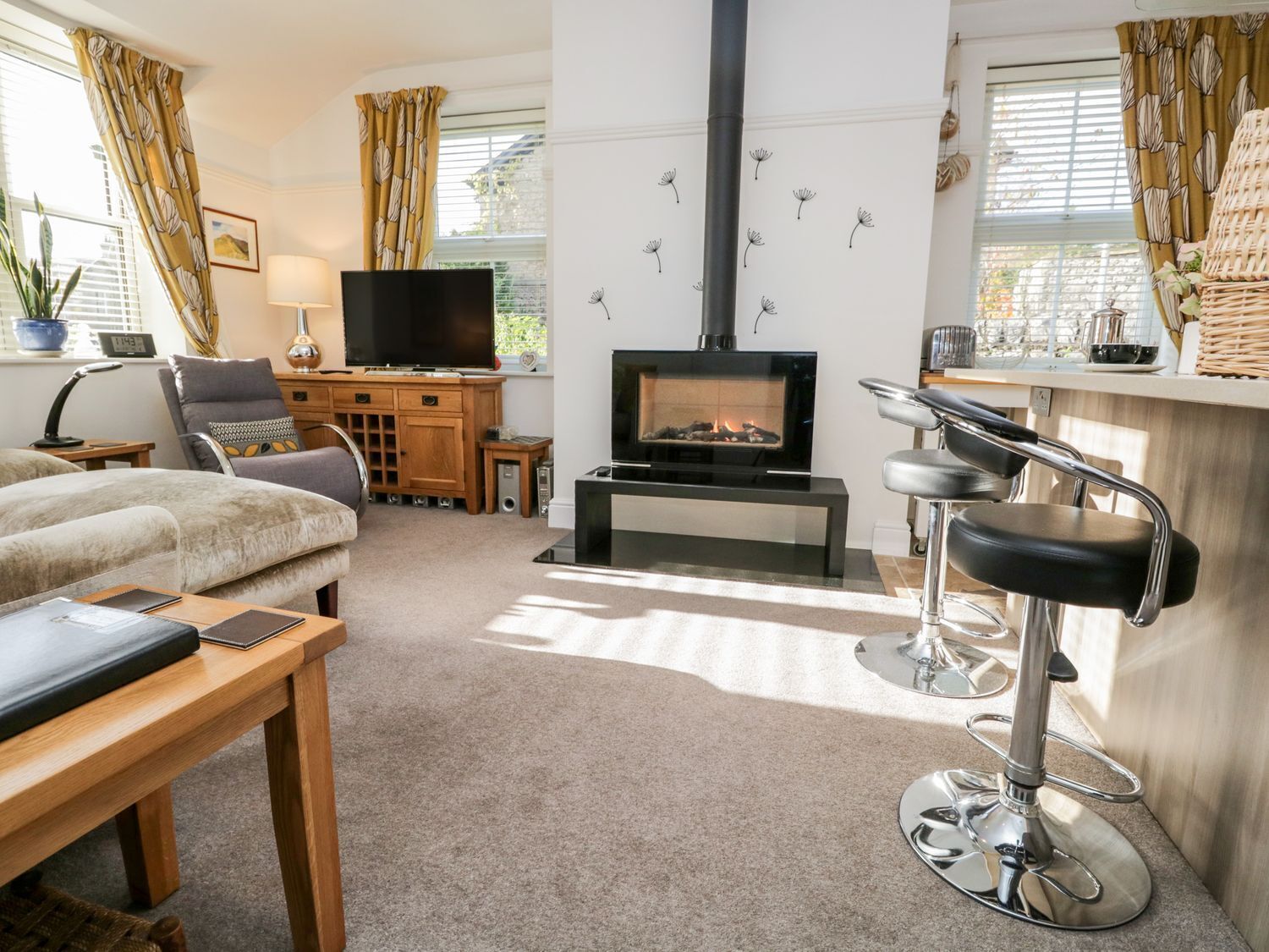 Una sala de estar acogedora con chimenea, televisión, un sofá cómodo y una zona de bar.