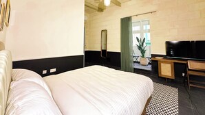 A bedroom with a large bed, a desk, a TV, and a ceiling fan. - Il Bekka Suites (Rabat)