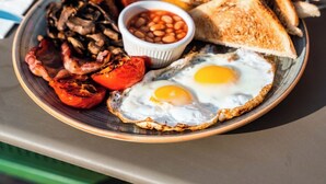 A breakfast plate with eggs, beans, toast, sausages, and mushrooms. - Il Bekka Suites (Rabat)