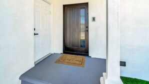 A clean, modern entrance with a dark door, a white door, and a welcome mat. - Private 1-Bedroom Retreat with Poolside Vibes (Los Angeles)