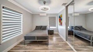 A bedroom with two single beds, a ceiling fan, and a large mirror. - Private 1-Bedroom Retreat with Poolside Vibes (Los Angeles)