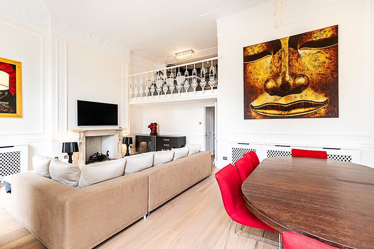 A modern living room with a sofa, a dining table, and a TV.