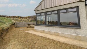 A single-story building with a sloped roof and large windows. - Castell Y Garn (Newport)