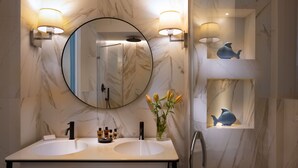 A bathroom with a double sink, a large mirror, and wall-mounted sconces. - Green Palm (Taormina)