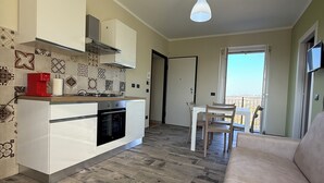 Un espacio habitable compacto con kitchenette, comedor y sofá.