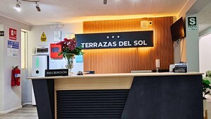 A reception desk with a sign reading "TERRAZAS DEL SOL" and a "RECEPTION" sign below it. - TERRAZAS DEL SOL (Arequipa)
