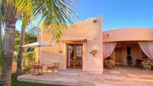 A house with a curved facade, a stone patio, and a small outdoor seating area with a table and chairs. - LADIES SPA VILLA RETREAT - Cave Creek, AZ
Day Spa, Full Moon Drum Circle & Meals (Phoenix)